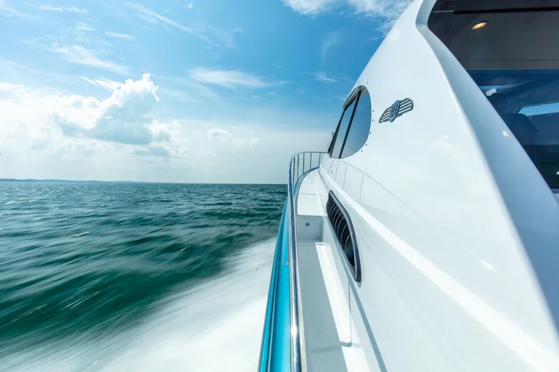 Slide: The Image of 2026 Palm Beach Motor Yachts GT50 cruising on open water under a clear blue sky. - 10