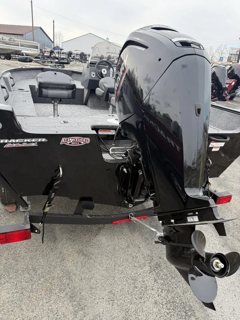 Slide: The Image of 2025 Tracker Pro Guide V-16 SC boat with powerful outboard motor, parked on a trailer. - 2