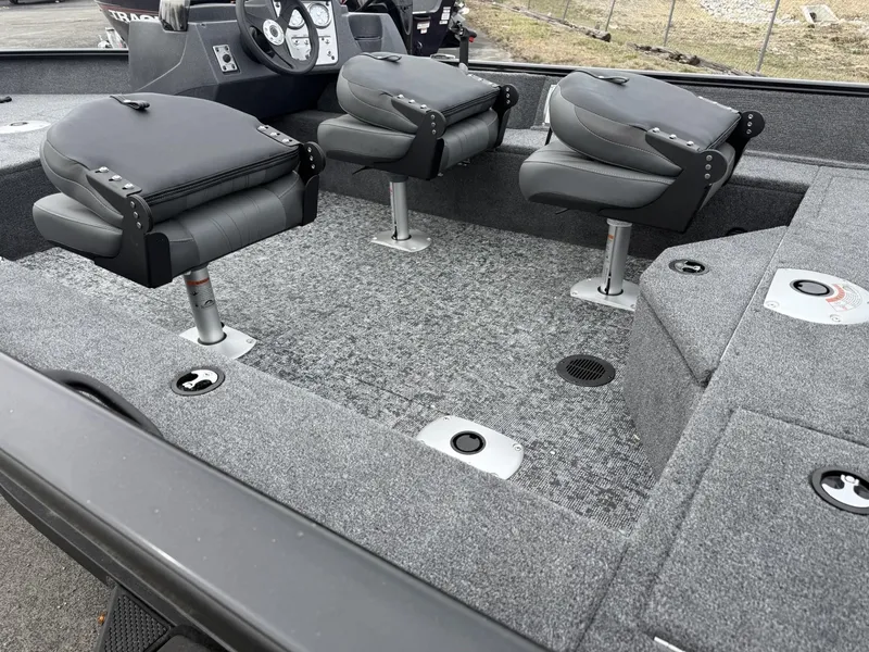 Slide: The Image of 2025 Tracker Pro Guide V-16 SC boat interior with three gray seats and carpeted flooring. - 4