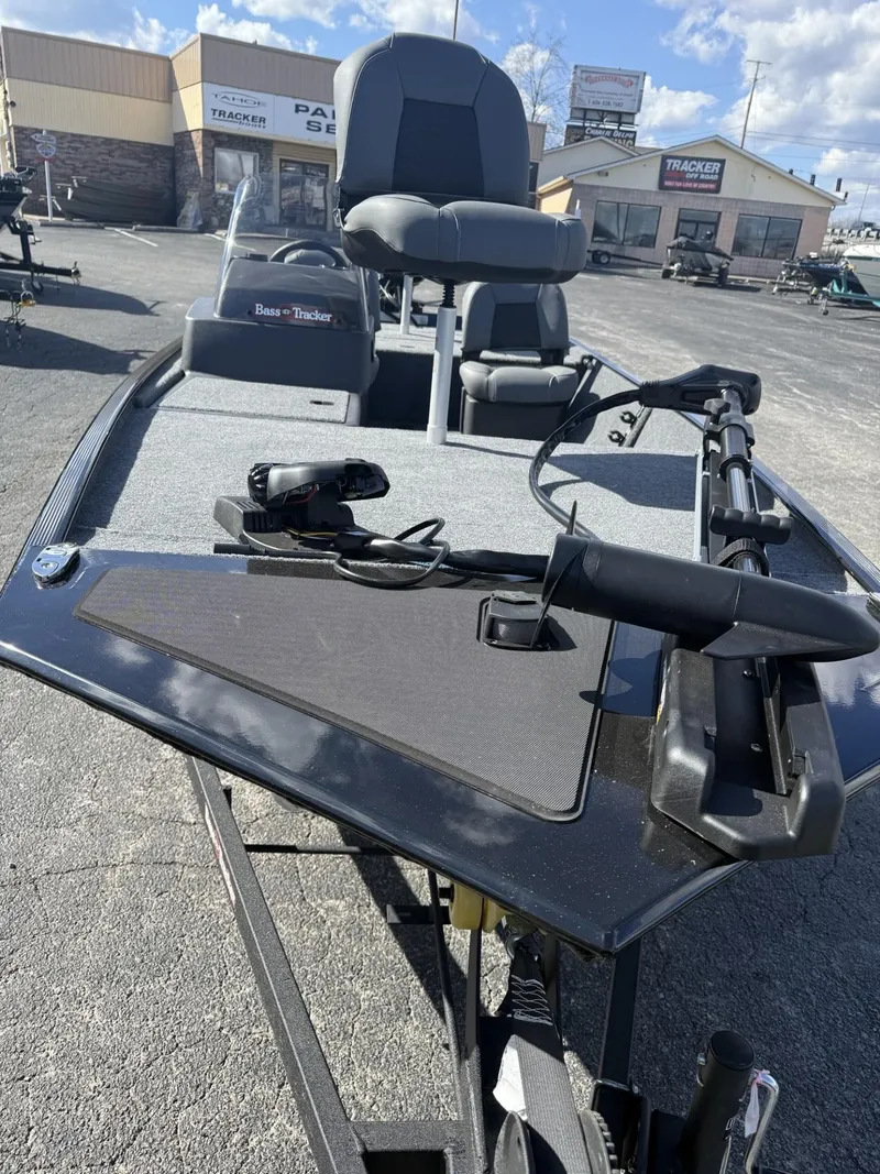 Slide: The Image of 2025 Tracker Bass Tracker Classic XL boat with fishing equipment on display outdoors. - 2