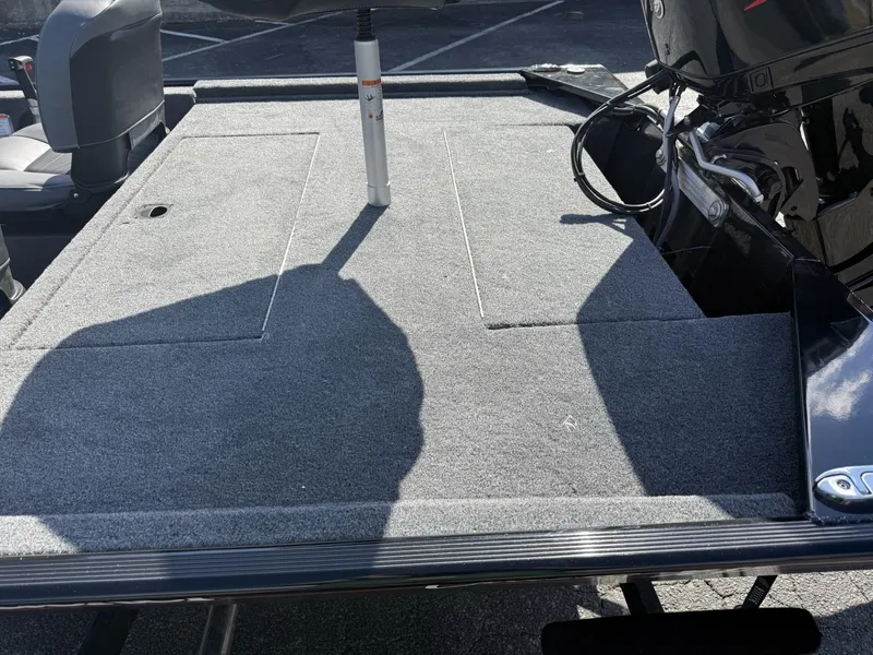 Slide: The Image of 2025 Tracker Bass Tracker Classic XL boat deck with motor, featuring a spacious carpeted surface. - 4