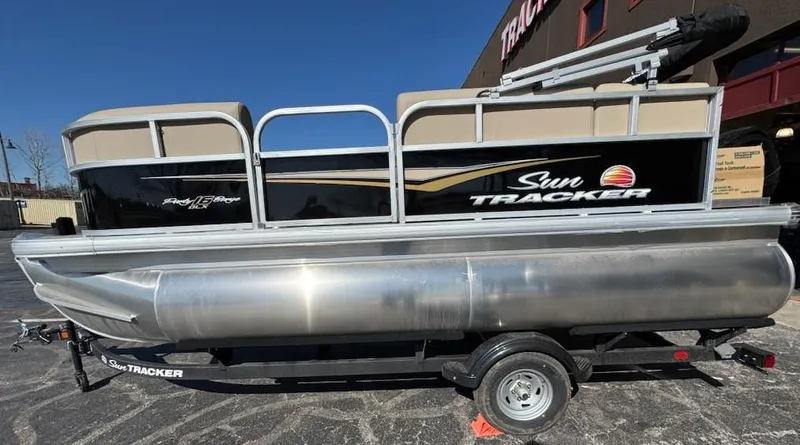Slide: The Image of 2025 Sun Tracker Party Barge 16 DLX pontoon boat on trailer, side view. - 4