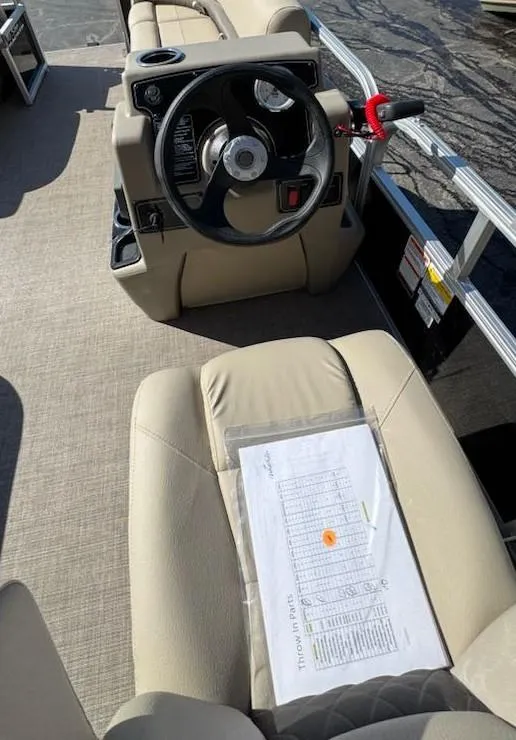 Slide: The Image of 2025 Sun Tracker Party Barge 16 DLX interior with steering wheel and seating. - 9