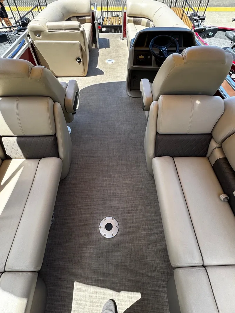Slide: The Image of 2025 Sun Tracker Party Barge 22 DLX interior with beige seating and steering console. - 3