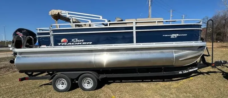 Slide: The Image of 2025 Sun Tracker Fishin' Barge 20 DLX pontoon boat on trailer, side view. - 5