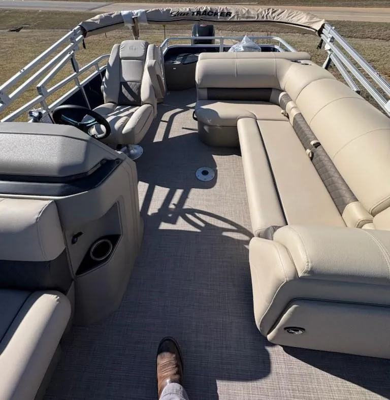 Slide: The Image of 2025 Sun Tracker Fishin' Barge 20 DLX interior with beige seating and steering console. - 8