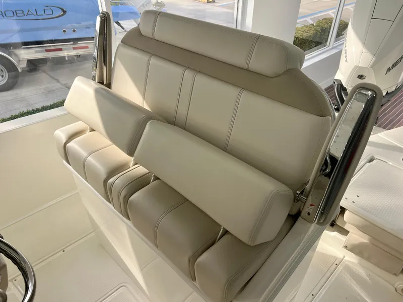 Slide: The Image of 2025 Boston Whaler 250 Dauntless boat seating, featuring beige cushioned seats and stainless steel armrests. - 10