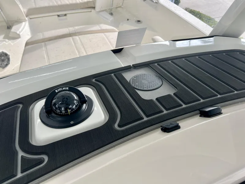 Slide: The Image of 2025 Boston Whaler 250 Dauntless dashboard with compass and speaker detail. - 16