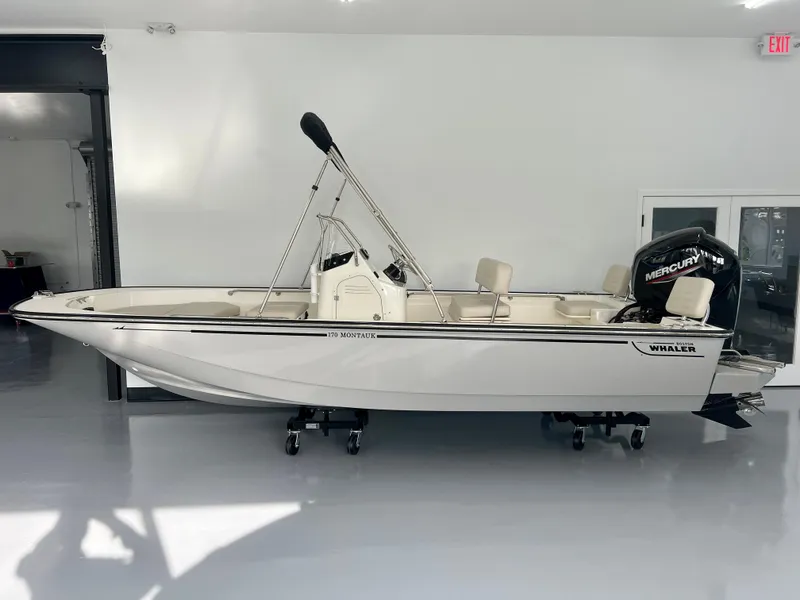 Slide: The Image of 2025 Boston Whaler 170 Montauk boat in showroom, side view. - 1