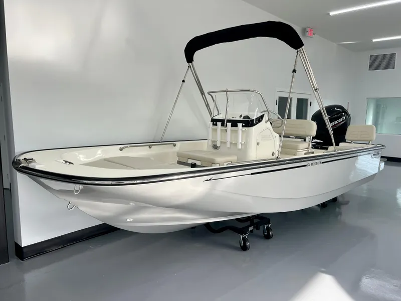 Slide: The Image of 2025 Boston Whaler 170 Montauk boat with canopy in showroom. - 2