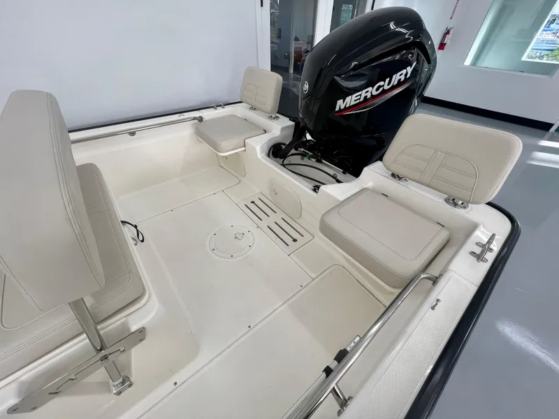 Slide: The Image of 2025 Boston Whaler 170 Montauk boat interior with Mercury engine, featuring cushioned seating. - 6