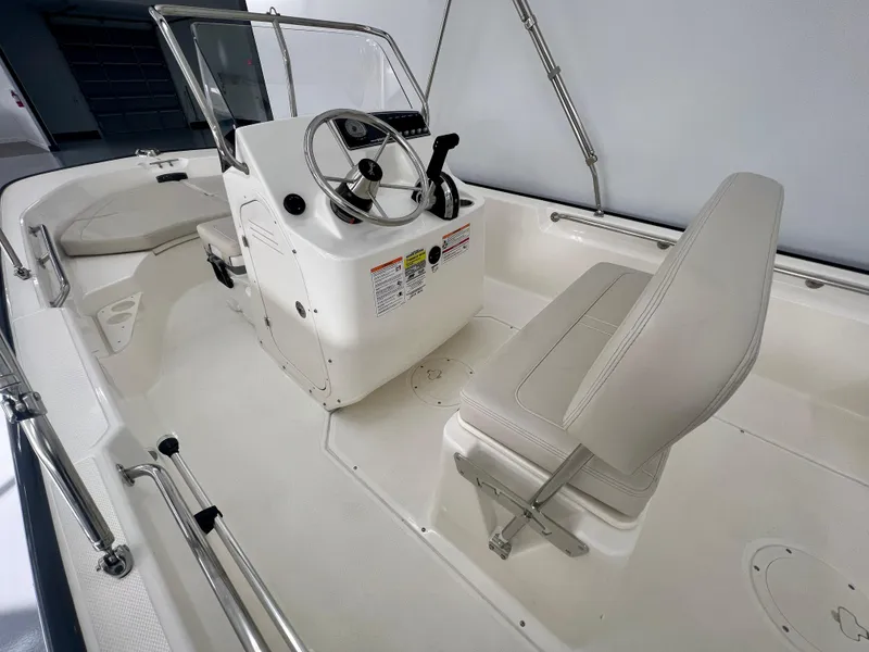 Slide: The Image of 2025 Boston Whaler 170 Montauk boat interior with steering console and seating. - 7