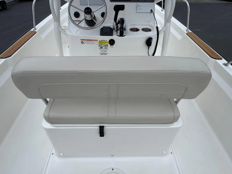 Slide: The Image of 2023 Boston Whaler 190 Montauk boat interior with beige seating and steering console. - 14