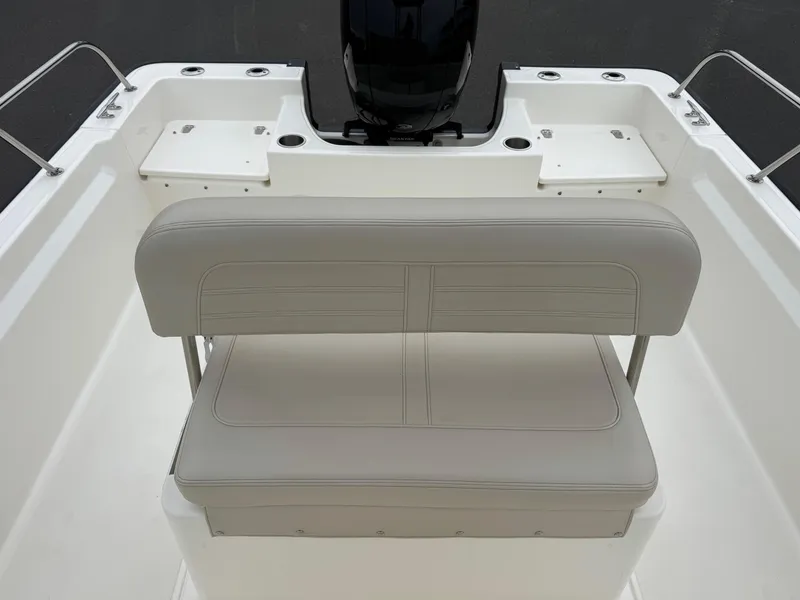Slide: The Image of 2023 Boston Whaler 190 Montauk boat interior with cushioned seating and motor area. - 15