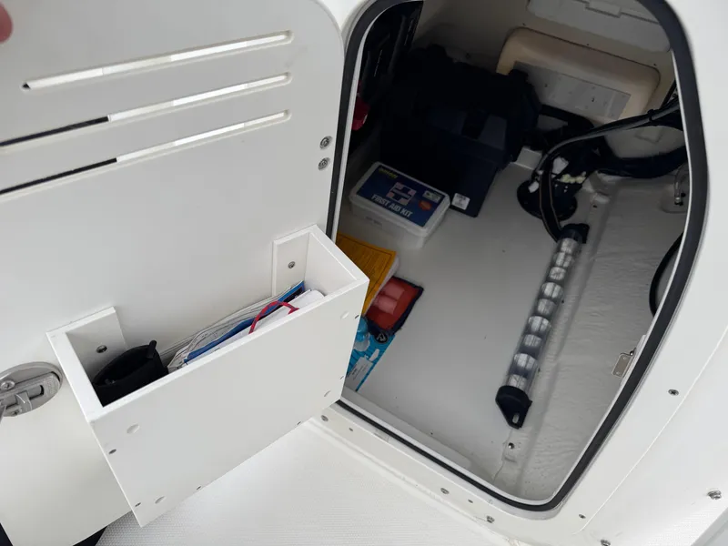Slide: The Image of 2023 Boston Whaler 190 Montauk storage compartment with organized boating essentials. - 17