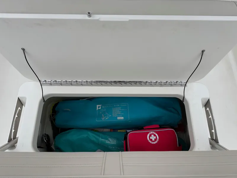 Slide: The Image of Storage compartment in 2023 Boston Whaler 190 Montauk with safety gear and first aid kit. - 18