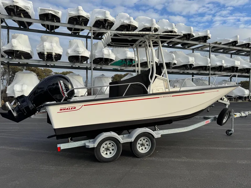 Slide: The Image of 2023 Boston Whaler 190 Montauk boat on trailer, with stacked boats in background. - 4
