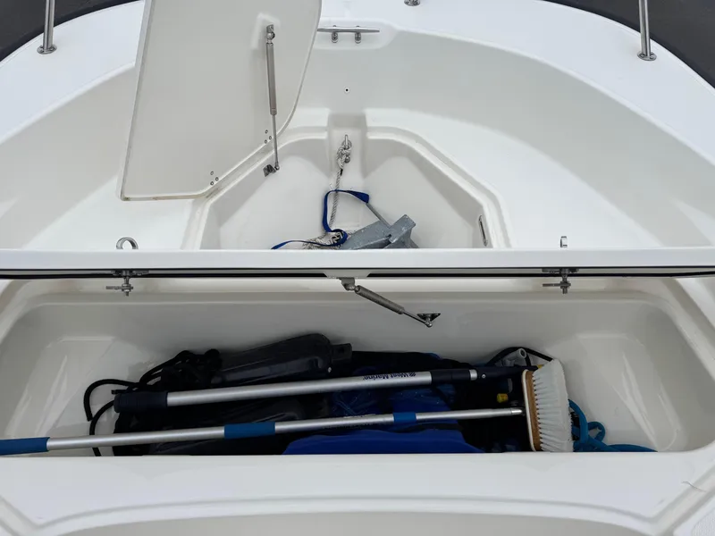 Slide: The Image of 2023 Boston Whaler 190 Montauk storage compartment with cleaning tools and anchor. - 7