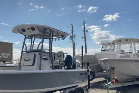Slide: The Image of 2025 Sea Pro 230 Bay boat on trailer under a clear blue sky. - 2