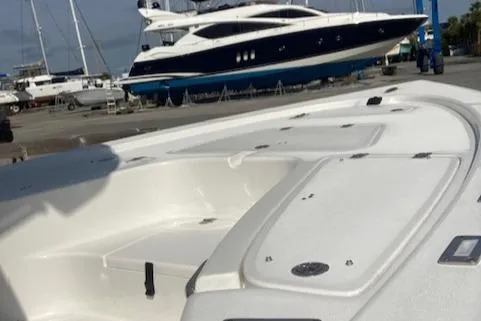 Slide: The Image of 2025 Sea Pro 230 Bay boat in marina, with yachts in the background. - 5