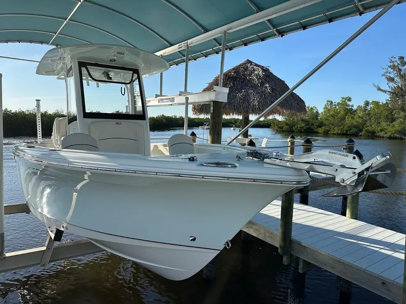 Slide: The Image of 2022 Sea Hunt Ultra 255 SE boat docked under canopy. - 0