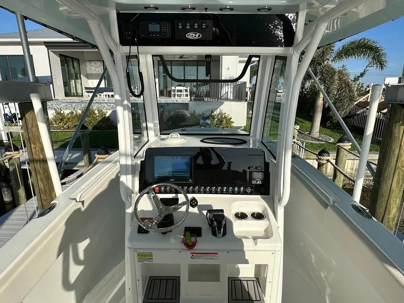 Slide: The Image of 2022 Sea Hunt Ultra 255 SE boat cockpit with steering wheel and control panel. - 14