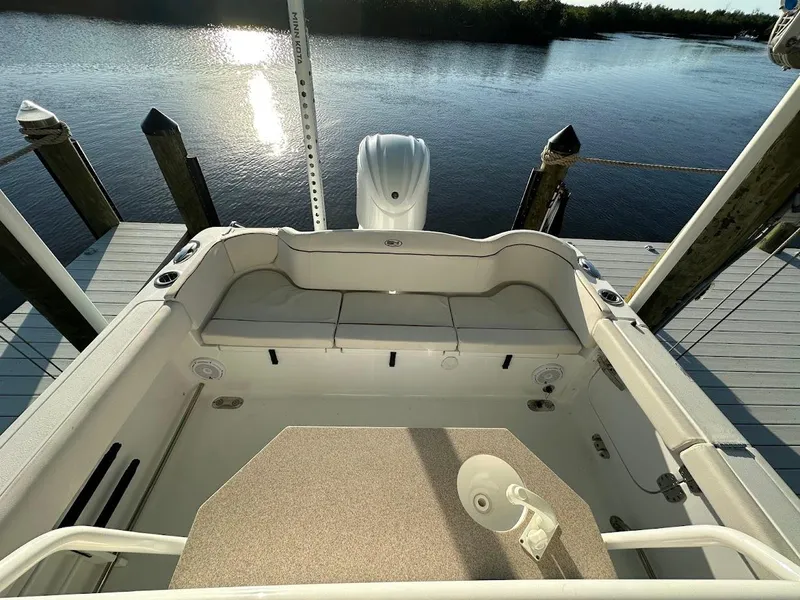 Slide: The Image of 2022 Sea Hunt Ultra 255 SE boat docked by serene waters at sunset. - 16