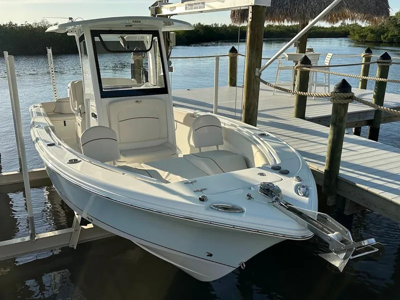 Slide: The Image of 2022 Sea Hunt Ultra 255 SE boat docked by a wooden pier. - 18