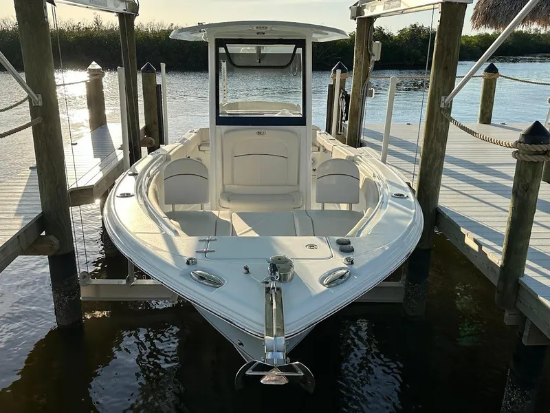 Slide: The Image of 2022 Sea Hunt Ultra 255 SE boat docked on calm water. - 19