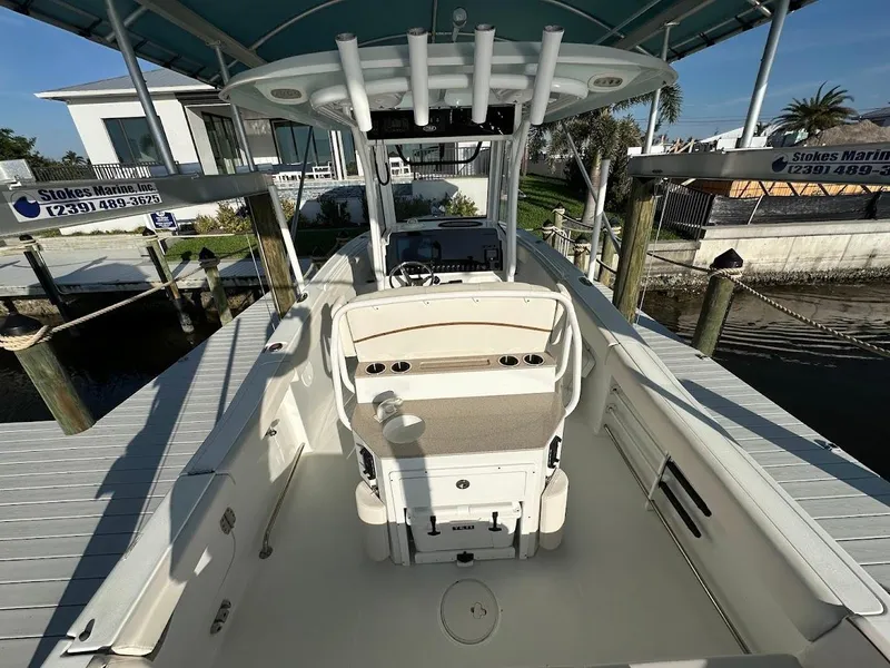 Slide: The Image of 2022 Sea Hunt Ultra 255 SE boat docked, showcasing spacious deck and seating area. - 6