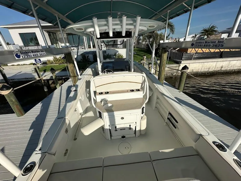 Slide: The Image of 2022 Sea Hunt Ultra 255 SE boat docked under canopy, showcasing spacious deck and seating. - 7