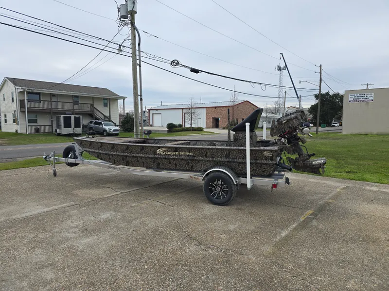 Slide: The Image of 2025 Pro-Drive 1848 SBX Stick Steer boat on trailer in parking lot. - 2