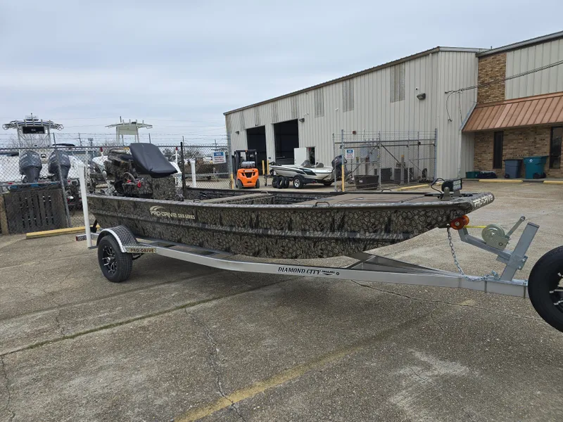 Slide: The Image of 2025 Pro-Drive 1848 SBX Stick Steer boat on trailer, parked outdoors. - 5