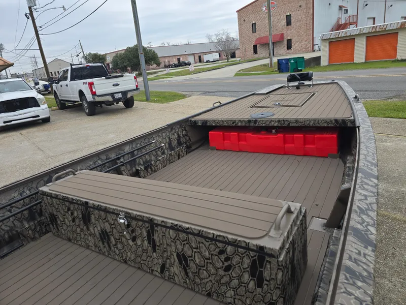 Slide: The Image of 2025 Pro-Drive 1848 SBX Stick Steer boat with camouflage design, parked outdoors. - 8