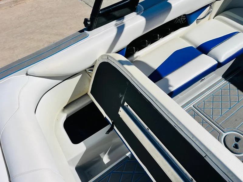 Slide: The Image of 2012 Moomba Mojo 2.5 boat interior with open storage compartment and blue-white seating. - 25