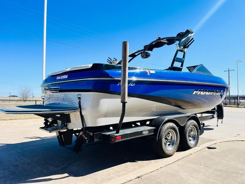 Slide: The Image of 2012 Moomba Mojo 2.5 boat on trailer, blue and white, parked outdoors. - 4