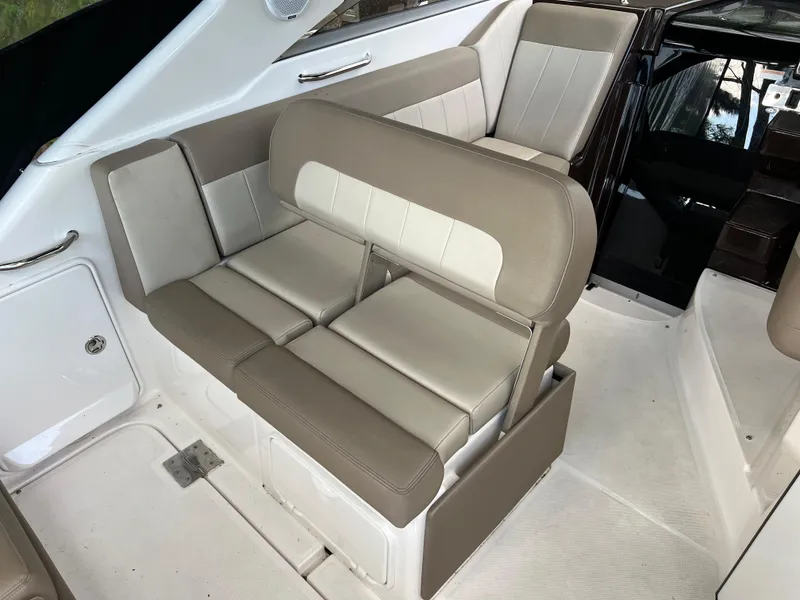 Slide: The Image of 2013 Regal 30 Express boat interior seating with beige and white upholstery. - 11