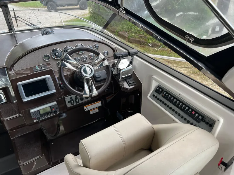 Slide: The Image of Cockpit of 2013 Regal 30 Express boat with steering wheel and control panel. - 15