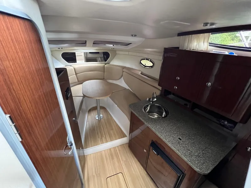 Slide: The Image of 2013 Regal 30 Express cabin interior with wood finishes and compact kitchenette. - 24