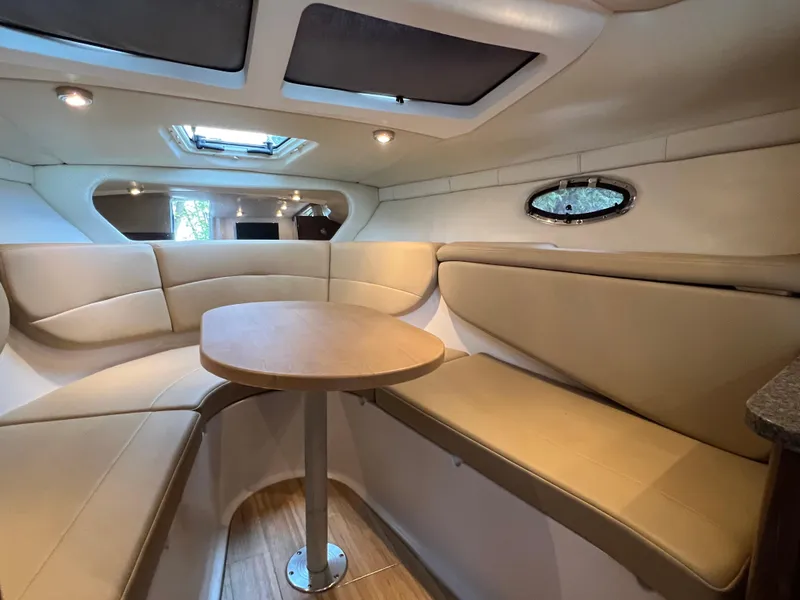 Slide: The Image of 2013 Regal 30 Express cabin interior with beige seating and round table. - 34