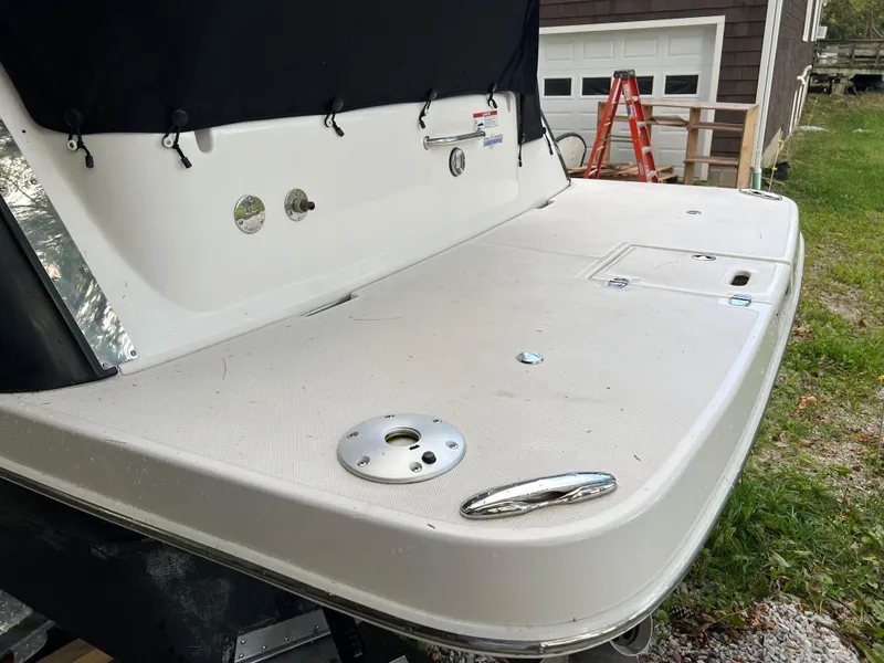 Slide: The Image of 2013 Regal 30 Express boat stern with swim platform and ladder in a yard setting. - 5