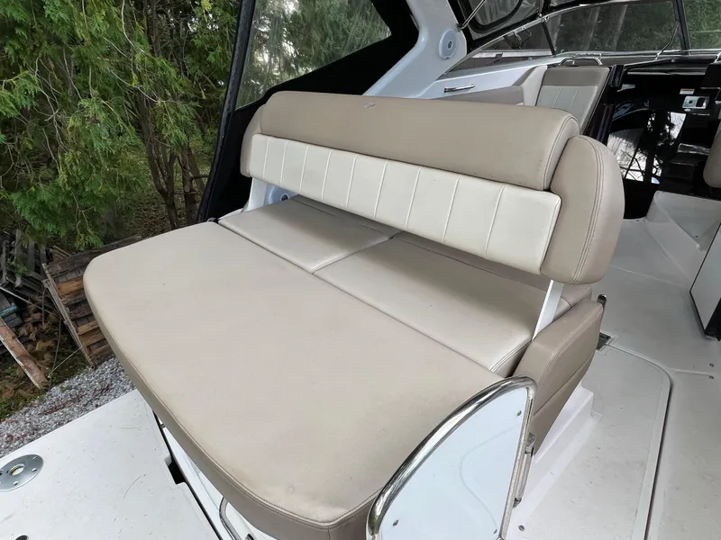 Slide: The Image of 2013 Regal 30 Express boat interior seating with beige upholstery. - 7