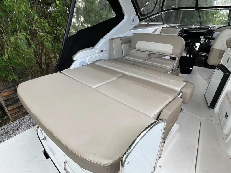 Slide: The Image of 2013 Regal 30 Express boat interior with beige seating and convertible lounge area. - 9