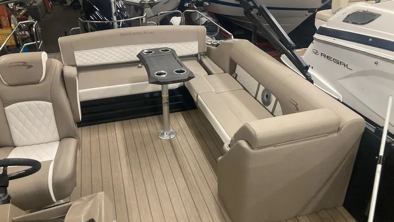 Slide: The Image of 2022 Bennington 25 LSB boat interior with beige seating and table. - 13