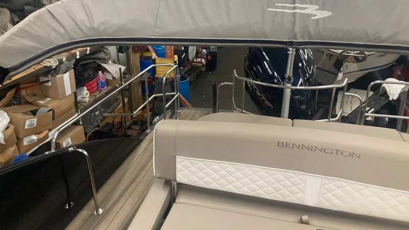 Slide: The Image of 2022 Bennington 25 LSB boat interior with beige seating and storage area. - 14
