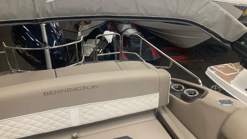 Slide: The Image of 2022 Bennington 25 LSB boat interior with beige seating and cup holders. - 15