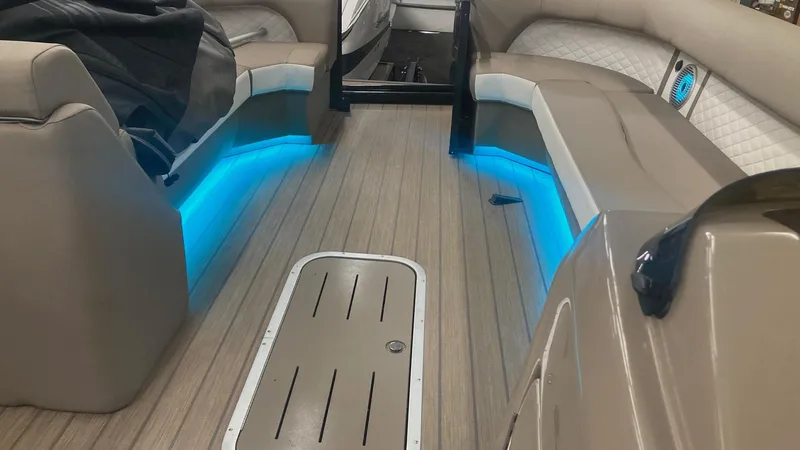 Slide: The Image of 2022 Bennington 25 LSB boat interior with blue LED lighting and cushioned seating. - 16