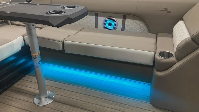 Slide: The Image of Luxurious interior of 2022 Bennington 25 LSB with ambient blue lighting and comfortable seating. - 17