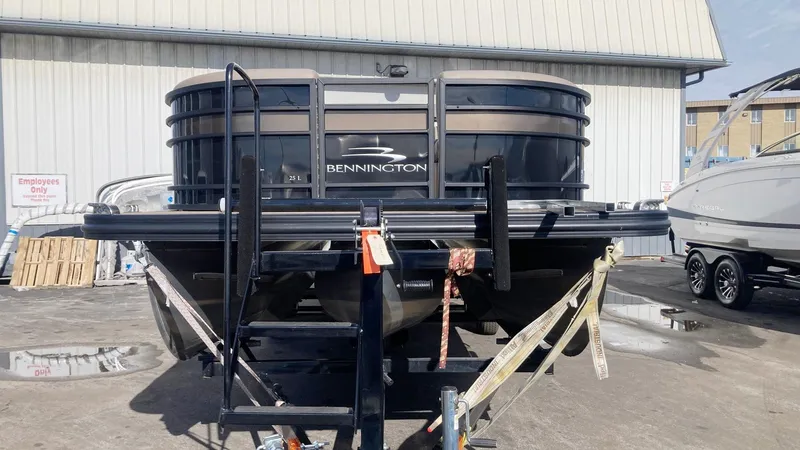 Slide: The Image of 2022 Bennington 25 LSB pontoon boat on trailer, parked outdoors. - 2