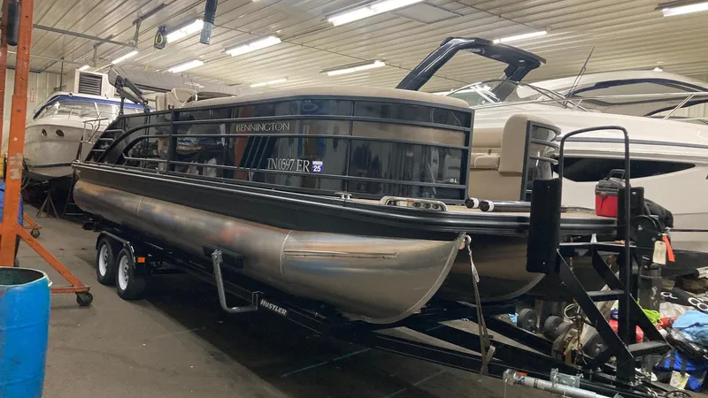 Slide: The Image of 2022 Bennington 25 LSB pontoon boat in indoor storage on a trailer. - 4